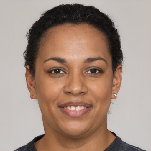 Joyful black young-adult female with short  brown hair and brown eyes
