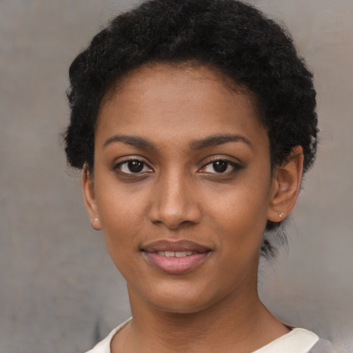 Joyful black young-adult female with short  brown hair and brown eyes