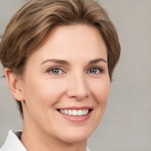 Joyful white young-adult female with short  brown hair and grey eyes