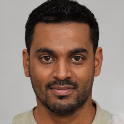 Joyful black young-adult male with short  black hair and brown eyes