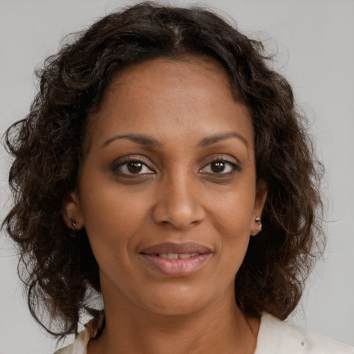 Joyful black adult female with medium  brown hair and brown eyes