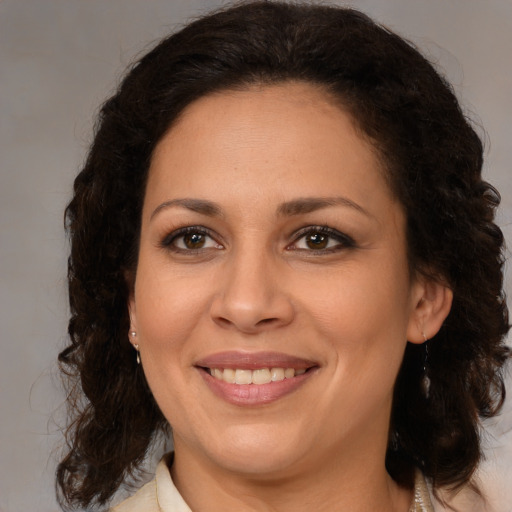 Joyful latino young-adult female with medium  brown hair and brown eyes