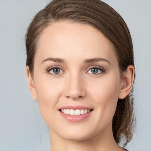 Joyful white young-adult female with long  brown hair and grey eyes