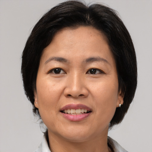 Joyful asian adult female with medium  brown hair and brown eyes