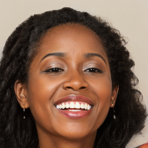 Joyful black young-adult female with long  brown hair and brown eyes