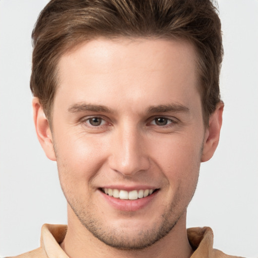 Joyful white young-adult male with short  brown hair and grey eyes