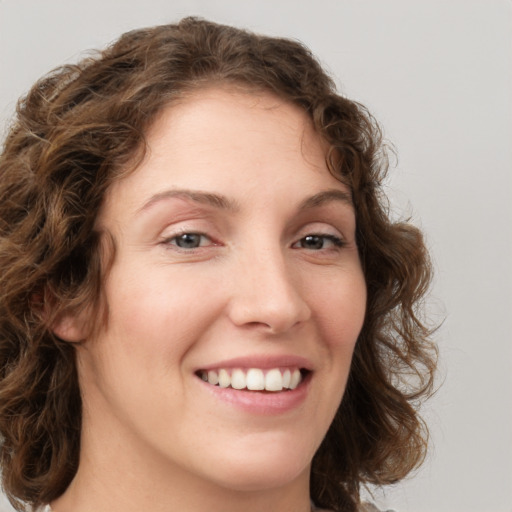 Joyful white young-adult female with medium  brown hair and green eyes