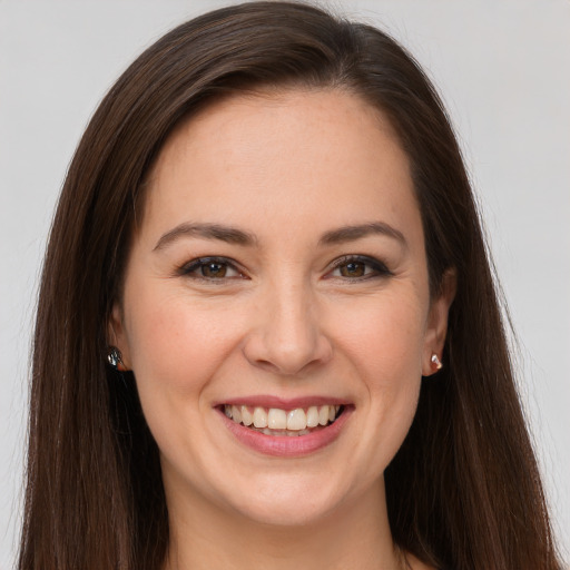 Joyful white young-adult female with long  brown hair and brown eyes