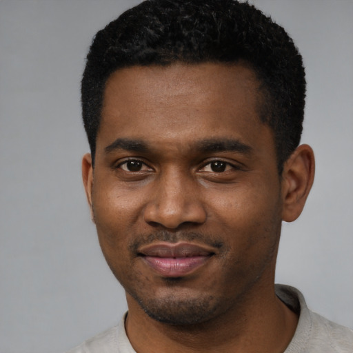 Joyful black young-adult male with short  black hair and brown eyes