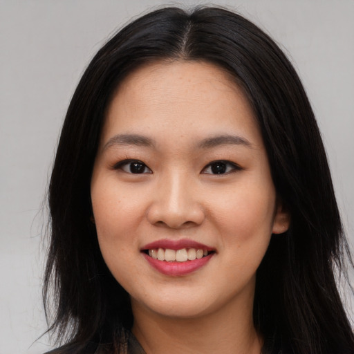 Joyful asian young-adult female with long  brown hair and brown eyes