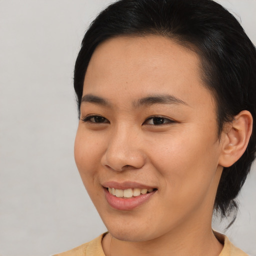 Joyful asian young-adult female with medium  brown hair and brown eyes