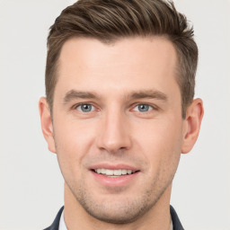 Joyful white young-adult male with short  brown hair and grey eyes