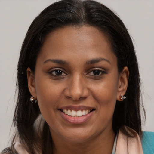 Joyful black young-adult female with long  brown hair and brown eyes