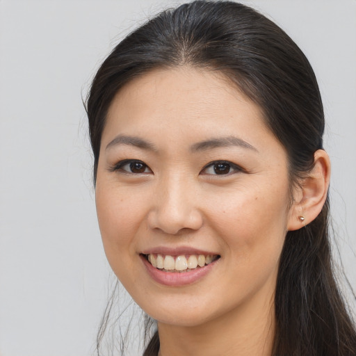 Joyful asian young-adult female with long  brown hair and brown eyes