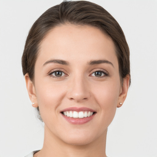 Joyful white young-adult female with short  brown hair and grey eyes