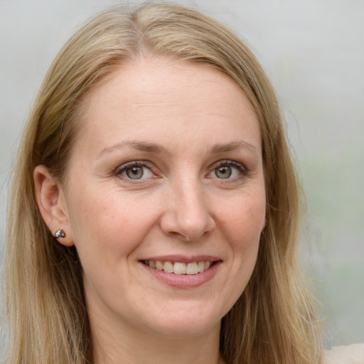 Joyful white adult female with long  brown hair and blue eyes