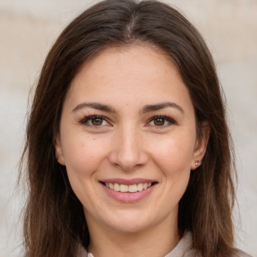 Joyful white young-adult female with long  brown hair and brown eyes