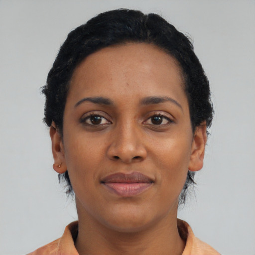Joyful black young-adult female with short  black hair and brown eyes