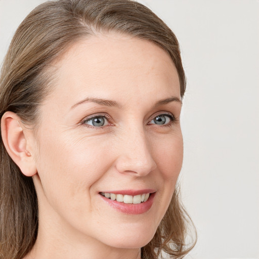 Joyful white young-adult female with long  brown hair and grey eyes