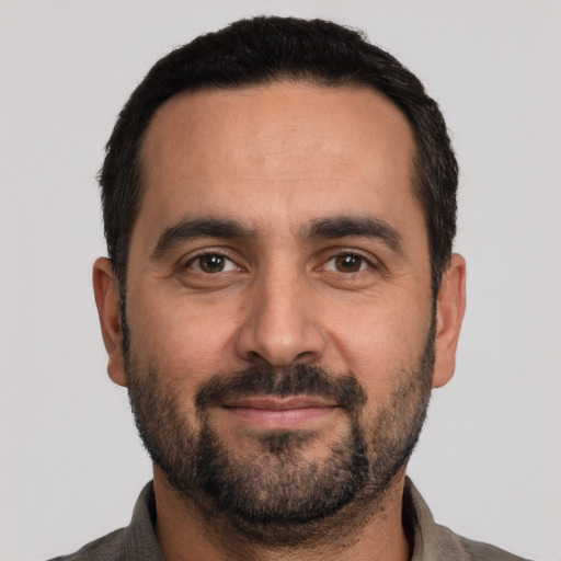Joyful white adult male with short  black hair and brown eyes