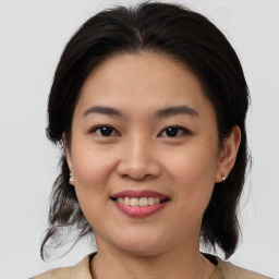 Joyful asian young-adult female with medium  brown hair and brown eyes