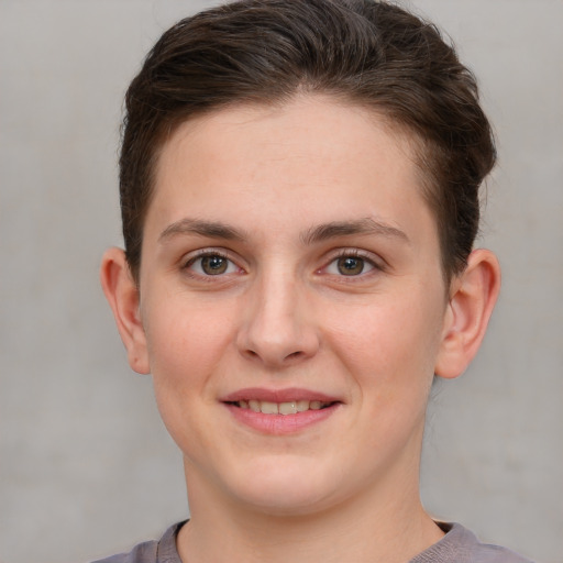 Joyful white young-adult female with short  brown hair and grey eyes