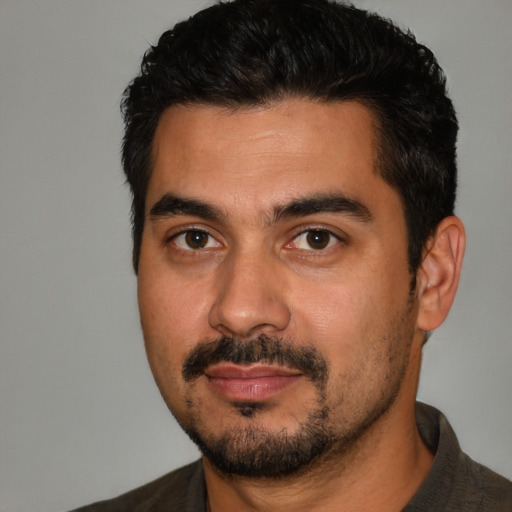 Joyful latino young-adult male with short  black hair and brown eyes