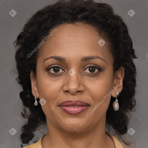 Joyful black adult female with long  brown hair and brown eyes