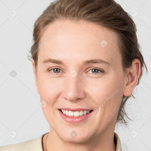 Joyful white young-adult female with short  brown hair and grey eyes