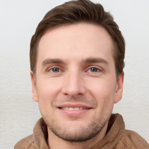 Joyful white young-adult male with short  brown hair and grey eyes