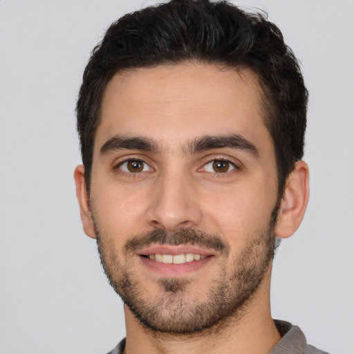 Joyful white young-adult male with short  black hair and brown eyes