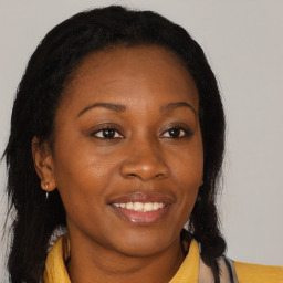 Joyful black young-adult female with long  brown hair and brown eyes