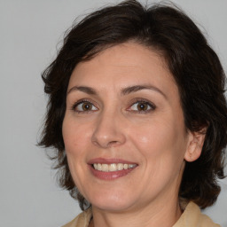 Joyful white adult female with medium  brown hair and brown eyes