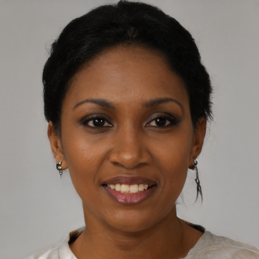 Joyful black young-adult female with short  black hair and brown eyes