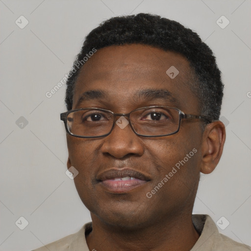 Joyful black adult male with short  black hair and brown eyes