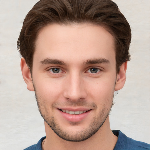 Joyful white young-adult male with short  brown hair and grey eyes