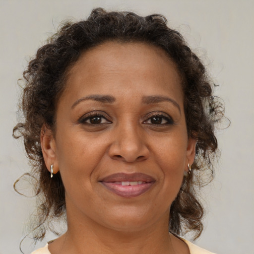 Joyful black adult female with medium  brown hair and brown eyes