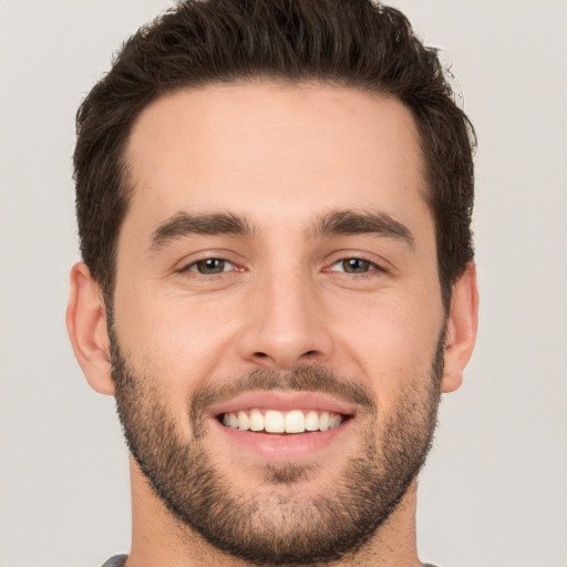 Joyful white young-adult male with short  brown hair and brown eyes