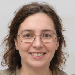 Joyful white adult female with medium  brown hair and green eyes