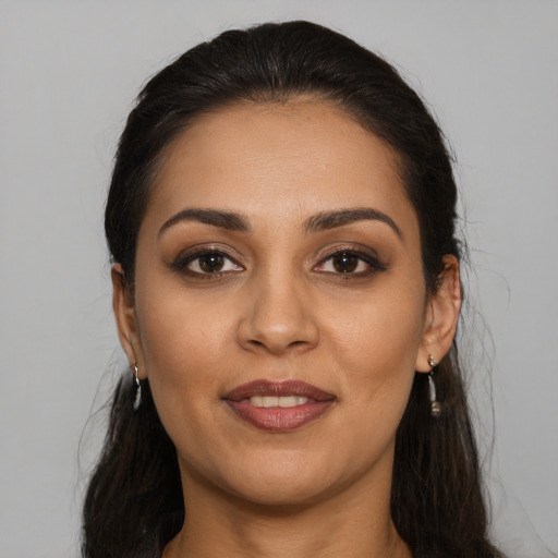 Joyful latino young-adult female with long  brown hair and brown eyes
