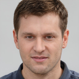 Joyful white young-adult male with short  brown hair and grey eyes