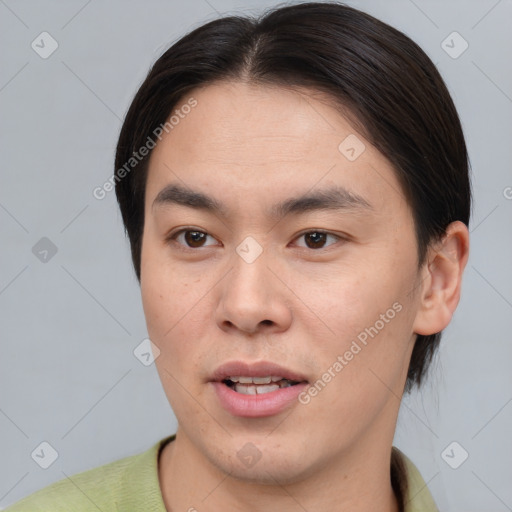 Joyful asian young-adult male with short  brown hair and brown eyes