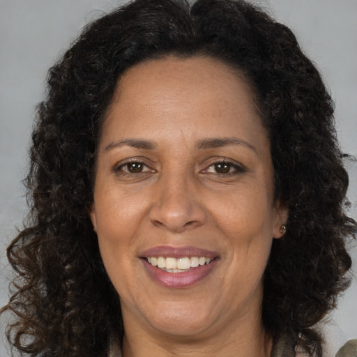 Joyful black adult female with long  brown hair and brown eyes