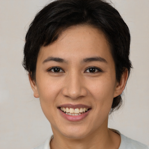 Joyful asian young-adult female with short  brown hair and brown eyes