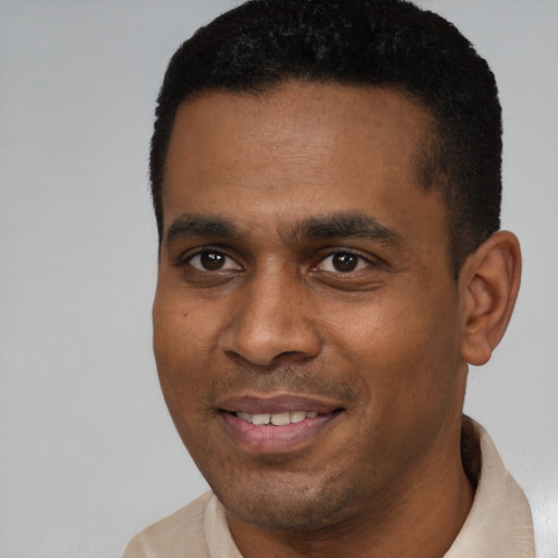 Joyful black young-adult male with short  black hair and brown eyes