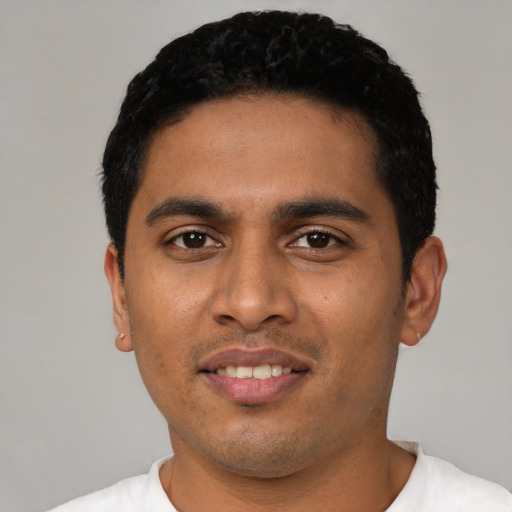 Joyful latino young-adult male with short  black hair and brown eyes
