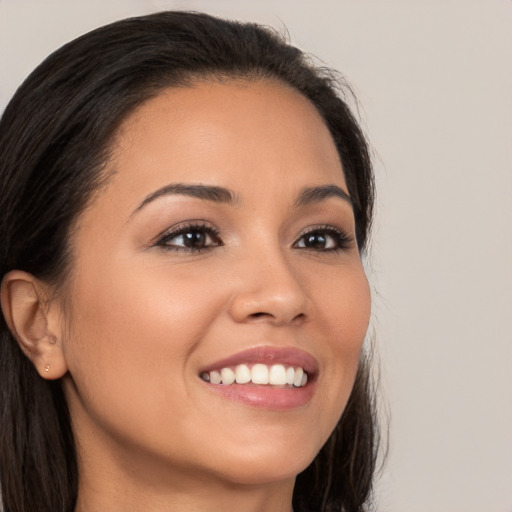 Joyful latino young-adult female with long  brown hair and brown eyes