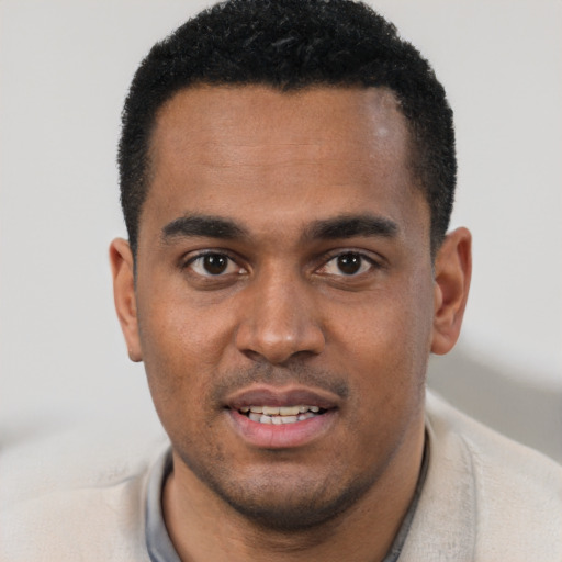 Joyful black young-adult male with short  black hair and brown eyes
