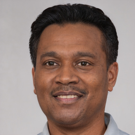 Joyful latino adult male with short  black hair and brown eyes