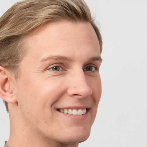 Joyful white young-adult male with short  brown hair and blue eyes